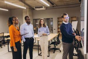 Diverse group of professionals engaged in a collaborative discussion in a modern office environment, highlighting teamwork and innovation photo