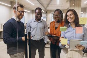Group of diverse professionals discussing ideas in a modern office setting, using technology for effective collaboration and innovation photo