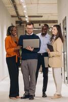 Diverse colleagues working together, sharing ideas and using technology to achieve common goals in a modern workspace photo