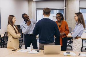 Diverse colleagues enjoying a lighthearted moment during a productive workday, fostering a positive and inclusive work environment photo
