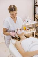 Skilled cosmetologist applies a facial mask to a client in a spa setting, emphasizing skincare and relaxation in a serene environment photo