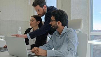 Diverse team corporate coworkers working laptops in office male business coach mentor boss businessman helping employees with computer work training new workers help interns check explain data project photo