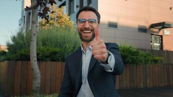 Caucasian happy successful businessman employer texting messages on mobile phone smiling man business entrepreneur using smartphone app browsing social network show thumb up approval gesture outdoors photo