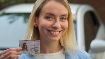 Joyful Caucasian businesswoman girl close up smiling hold driver license id certificate in city female automobile owner showing document driving school student exam woman buying auto renting vehicle photo