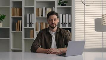 Caucasian smiling freelancer happy male businessman employer man guy working laptop at office desk writing startup business project online computer network e-learning studying in university library photo