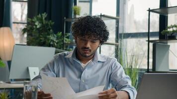 Focused businessman business person accountant office worker writing ideas in notebook paperwork Arabian Indian student write notes data information e-learning with laptop computer educational course photo