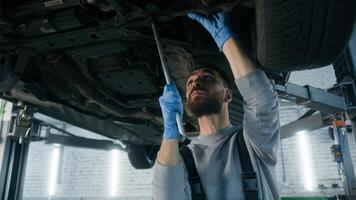 Caucasian man guy technician repairman auto mechanic repair truck in car service station male working underneath lifting vehicle in garage transport maintenance fixing automobile with mechanical tool photo