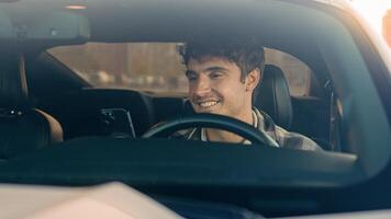 Happy smiling business man using phone apps in car urban driving lifestyle with mobile app technology smartphone in auto gps navigation. Cheerful male guy driver automobile waiting in city traffic jam photo