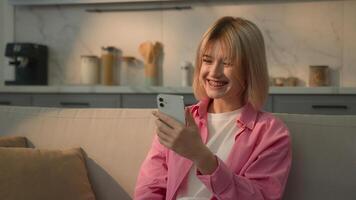 Caucasian woman at couch sofa typing chat message girl female lady influencer user using mobile phone browsing smartphone app social media internet online shopping at home chatting e-commerce addict photo