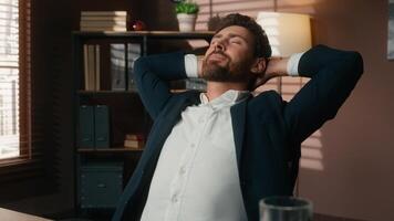 Successful smiling Caucasian middle-aged business man businessman guy male employer in office at table finish online working end computer job complete laptop task done relaxing hands behind head pause photo