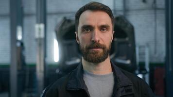 Close up portrait adult guy Caucasian man male industrial worker auto mechanic technician professional engineer repairman in uniform serious face looking camera in car service garage machinery factory photo