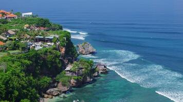Uluwatu area coastline with scenic cliffs, rock and ocean with best waves in Bali. Scenic landscape with hotels and resorts in Bukit video