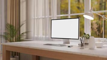 A computer and decorative items on a white marble desk, set against a window in a minimalist room. photo