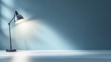 desk lamp casting soft glow on simple workspace with blue wall photo