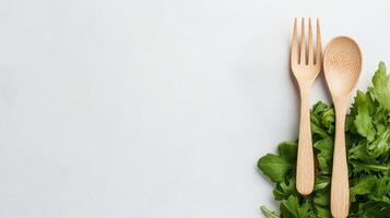Neatly arranged wooden spoon and fork on fresh green salad leaves photo