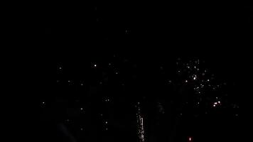 Brilliant burst of colorful fireworks illuminating the night sky, radiating golden and silver streaks with sparkling lights, creating a celebratory and festive atmosphere against the dark night sky video