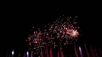Brilliant burst of colorful fireworks illuminating the night sky radiating golden and silver streaks with sparkling lights, creating a celebratory and festive atmosphere against the dark night sky video