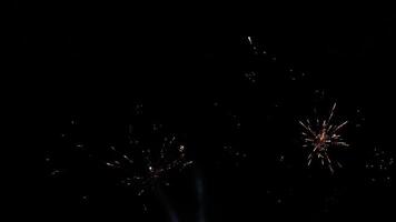 Brilliant burst of colorful fireworks illuminating the night sky radiating golden and silver streaks with sparkling lights creating a celebratory and festive atmosphere against the dark night sky video