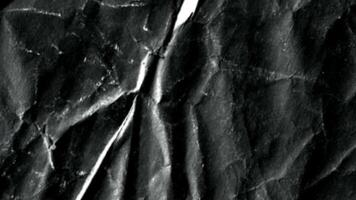 Black crumpled paper stop motion animation, Textured paper background. The concept of sketch pad, design, retro style, wrinkle, frayed, blank video
