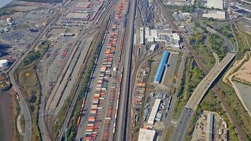 Aerial view of cargo train terminal with containers and tracks in an industrial area, large cargo train terminal with colorful containers and tracks in an industrial setting video