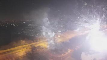 Bright red fireworks display filling the night sky over cityscape, illuminated streets and festive atmosphere. video