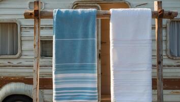 Towels drying on rack in front of a camper. photo