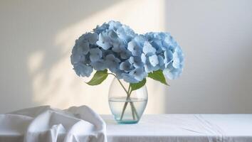 Blue Hydrangeas in Clear Vase on White Table photo