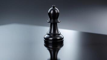 A Glossy Black Chess Pawn Positioned on a Smooth Reflective Surface Enhancing Its Appeal photo