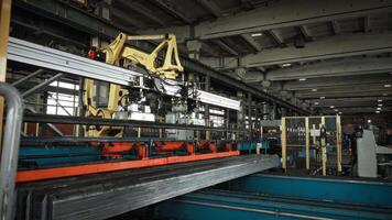 A large automated robot manipulator unloads heavy steel parts from a conveyor line. Automation in heavy industry. video
