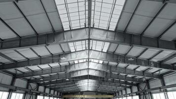 Ceiling of an industrial warehouse or workshop, with a large window. The beams in the roof structure provide strength and rigidity. video