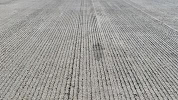 Stripes in Concrete A close-up view of a newly poured concrete surface with evenly spaced, deep grooves, creating a hypnotic pattern that speaks to the beauty of repetition and precision. photo