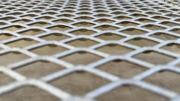 Diamond Mesh Texture Close-up view of a metallic diamond mesh, showcasing its intricate pattern and geometric design. The image offers a detailed texture ideal for design projects. photo