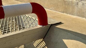Industrial Walkway Detail Close-up view of a metallic industrial walkway with red and white safety handrail, showcasing the precise construction and safety features. photo