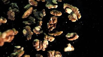 Slow Motion Walnut Pieces Falling on a Dark Background in a Studio Setting video