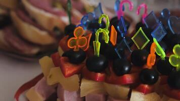 Bright skewers with red tomato, yellow cheese and dark olives are neatly arranged on a white plate video