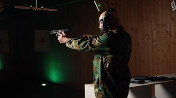 Portrait of cheerful military unit using tactical operations equipment, shooting pistol. Joyous army soldier in firing range preparing for mission, practicing with weapon, camera A video