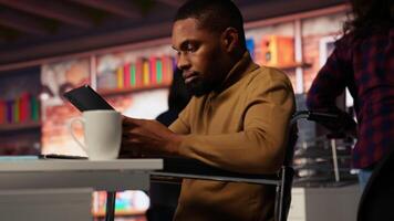 Commencez entrepreneur dans fauteuil roulant en utilisant tablette à faire recherche, à la recherche à grandir valeur de entreprise. entreprise affaires directeur avec invalidité en utilisant appareil, développement innovant croissance stratégie, caméra b video