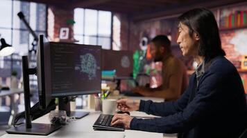 Software engineer in small business workspace using computer to oversee artificial intelligence neural networks. Person in tech startup office using AI machine learning systems on PC, camera B video