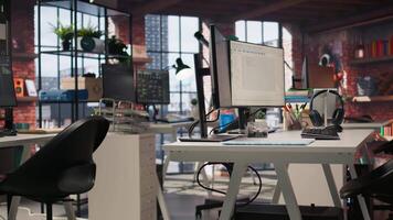 Empty AI tech agency workspace providing custom software development services. Machine learning technology running on PC in startup office to streamline coding process, jib up shot video