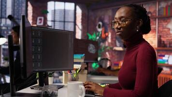 Silicon Valley venture programmer solving tasks with AI LLM chatbot using predictive technology. African american startup IT worker using PC to interact with generative model, camera B video