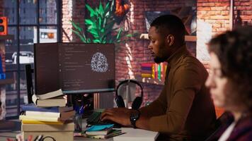 Startup company back end developer fixing applications issues, dealing with databases and server configuration. Man in office optimizing software for improved performance and scalability, camera B video