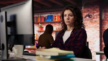 Woman using PC in startup office to design and implementing algorithms enabling machine learning. Technology unicorn venture employee conducts detailed code reviews to fix bugs, camera B video