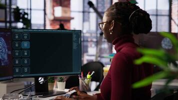 IT technician in startup office using large language model to get help with coding project. IT specialist interacting with AI LLM chatbot on PC in software development business company, camera B video