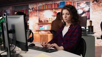 Woman using PC in startup office to design and implementing algorithms enabling machine learning. Technology unicorn venture employee conducts detailed code reviews to fix bugs, camera A video