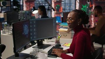 Silicon Valley venture programmer solving tasks with AI LLM chatbot using predictive technology. African american startup IT worker using PC to interact with generative model, camera A video