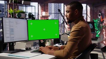 Programmer coding in startup office using green screen PC, building scalable solutions for businesses. AI industry startup technician leverages machine learning technology on mockup computer, camera B video