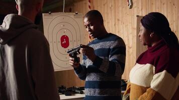 Shooting range safety officer ensuring clients are following regulations and operating firearms safely. African american firing range gallery worker giving instructions to customers, camera A video