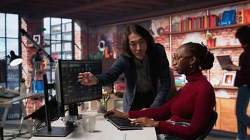 Artificial intelligence startup company manager overseeing programmer building application. Asian team leader assisting worker in AI software development agency, offering advice, camera A video