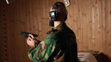 Cheerful army unit in firing range shooting targets with pistol pleased after achieving positive result. Excited soldier training with weapon thrilled after accurately hitting bullseye, camera A video