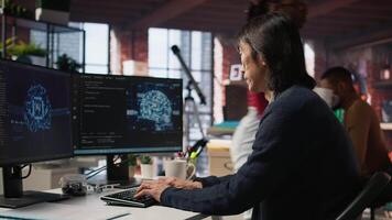 Software engineer in small business workspace using computer to oversee artificial intelligence neural networks. Person in tech startup office using AI machine learning systems on PC, camera A video